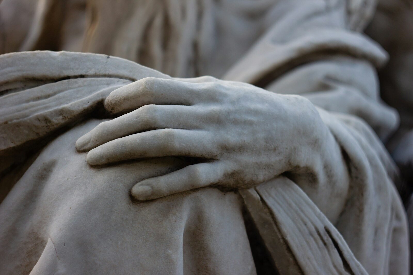 A close up of a statue of a person with his hands on his chest